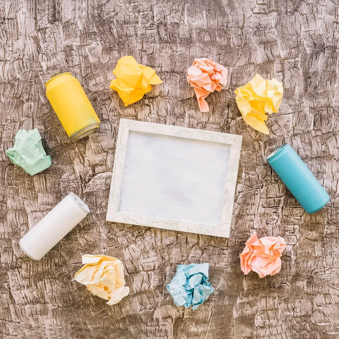 Ein Bilderrahmen, umgeben von Blechdosen und zerknüllten Papieren